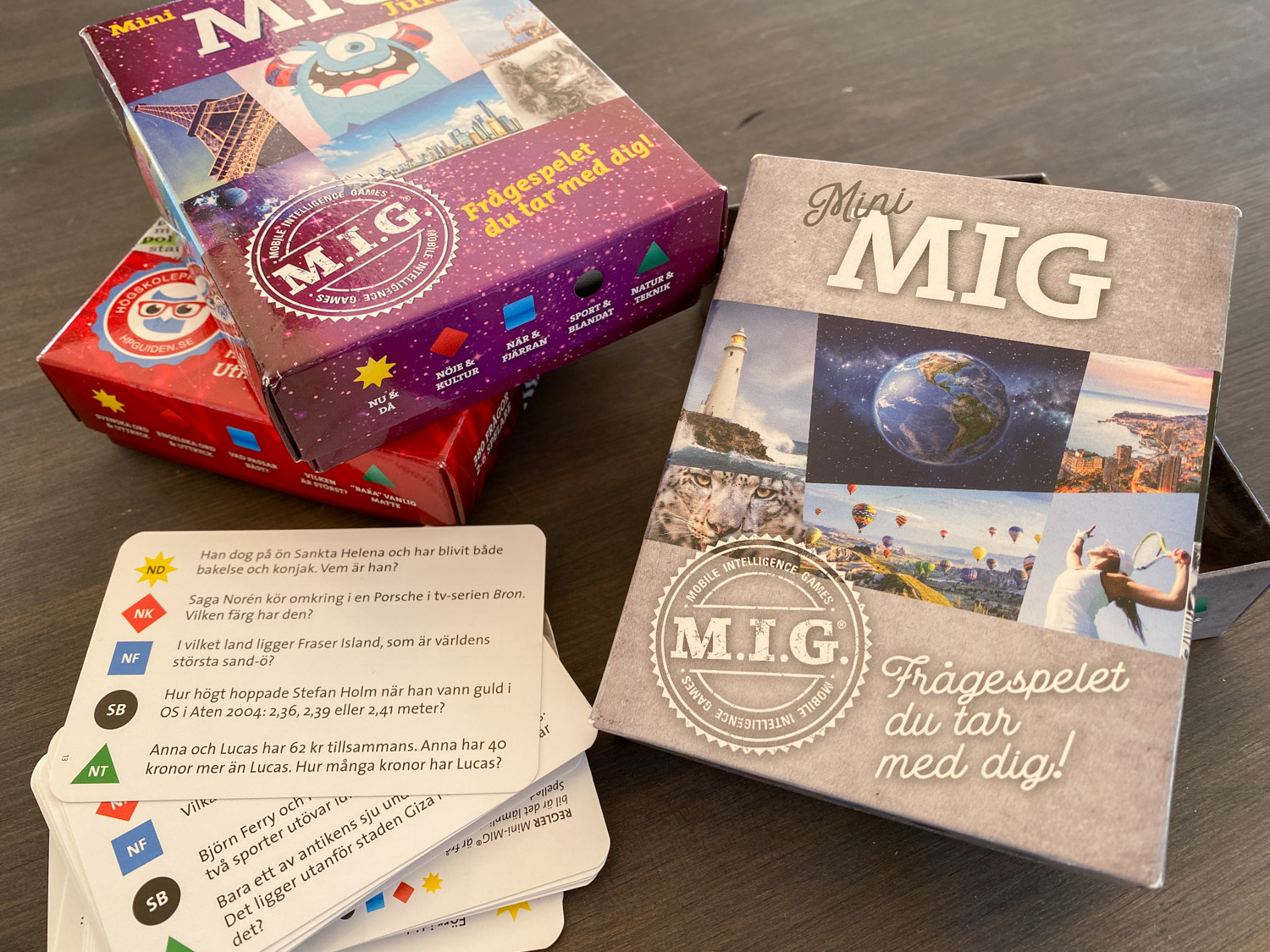 Ett spel i frågesportsform ligger på ett bord. Man ser flera kartonger och en hög med frågekort.