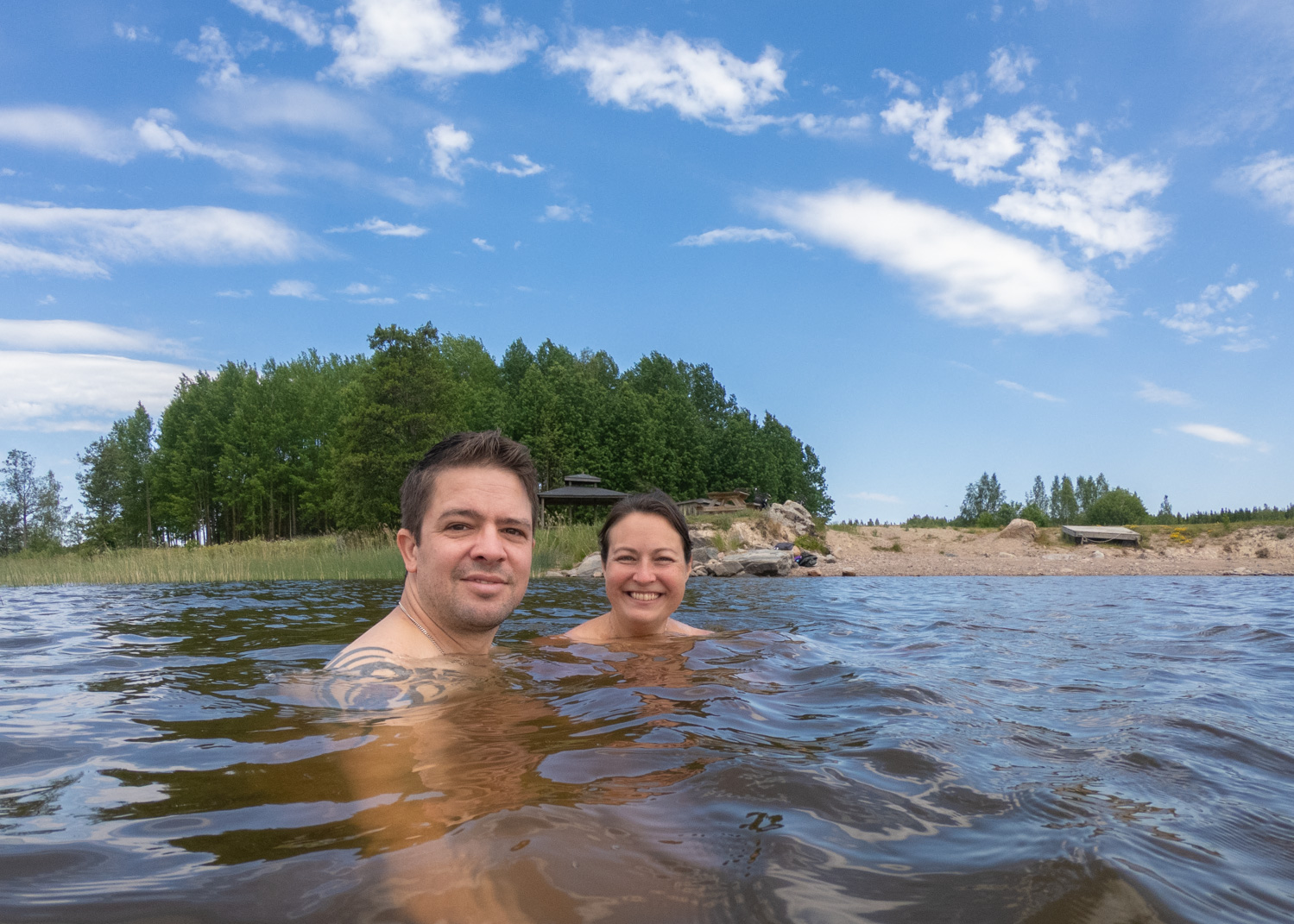 Ett ungt par badar i en sjö.