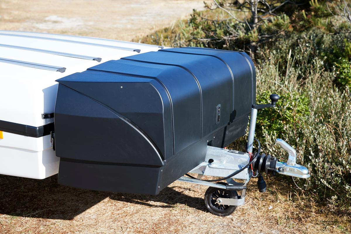 En vit camp-let-vagn med en stängd bagagebox fastsatt på dragstången.