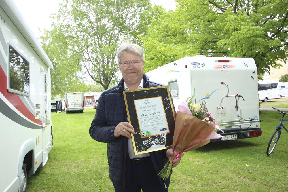 Man står med diplom för Sveriges Husbilsvänligaste Kommun i handen.