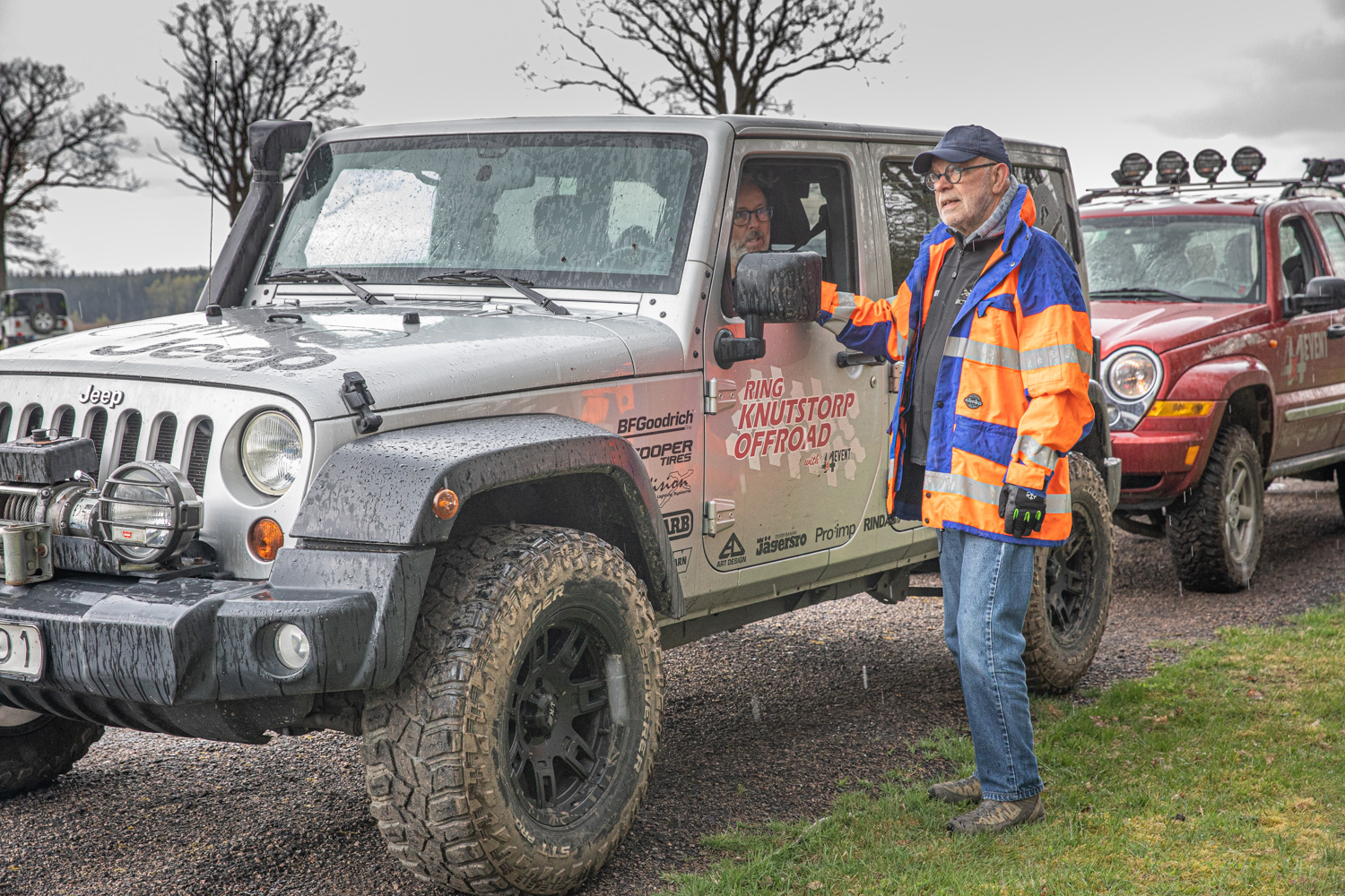 Två Jeeps på rad, en grå står först. Inne i bilen sitter en man och lyssnar på instruktören Dan Rettmark som står utanför.