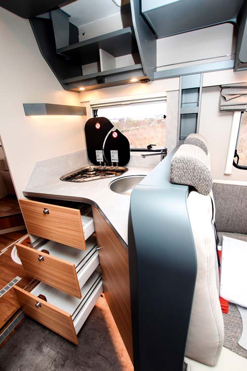 Kök med tre rätt rymliga lådor, överskåp, diskho och spis i Dethleffs Pulse T 7051 DBM