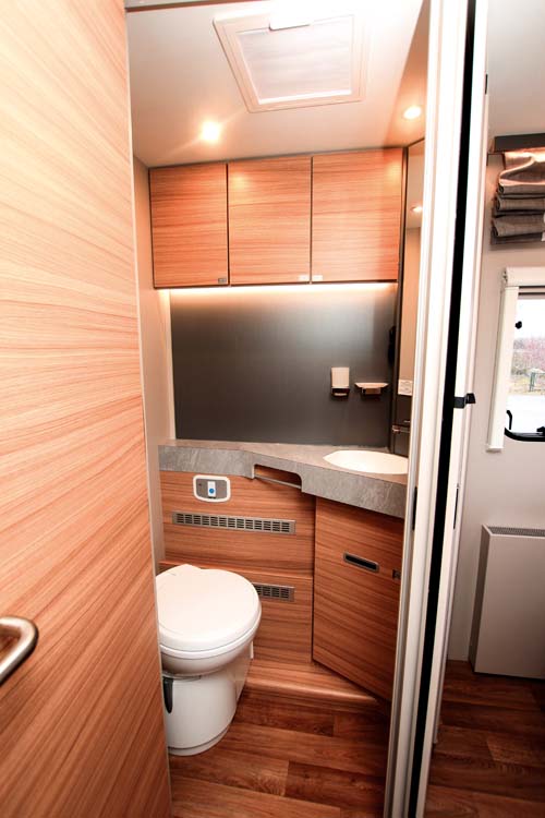 Badrum med överskåp och ett underskåp under handfat samt toalett i Dethleffs Pulse T 7051 DBM