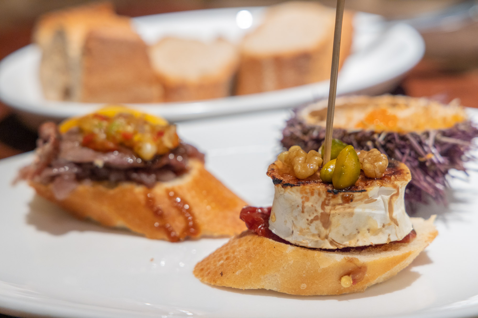 Pintxos. En liten baguettskiva med getost och valnötter.
