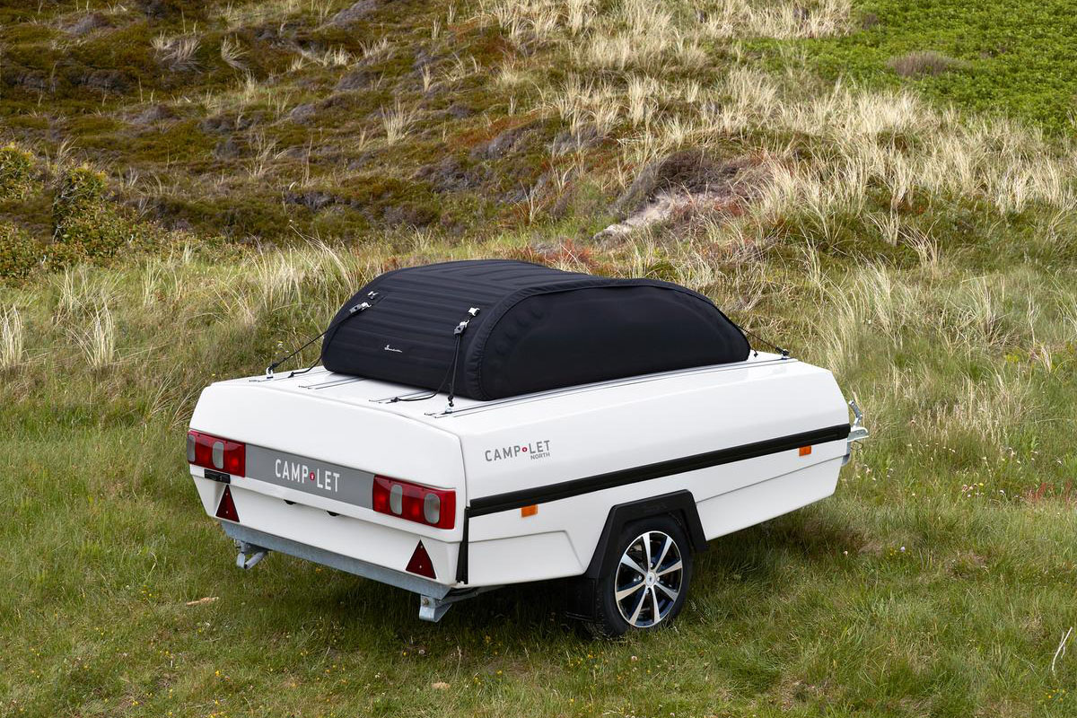 En vit camp-let-vagn med en liten takbox.