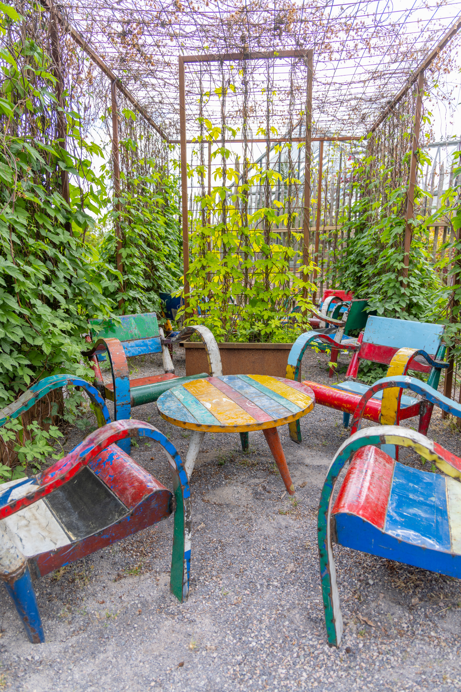 Färgglada utemöbler i en pergola.