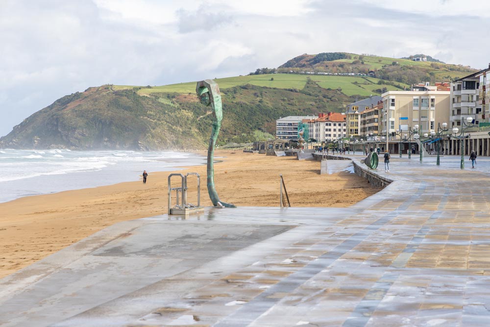 Strandpromenad med butiker och strand i Zarautz.